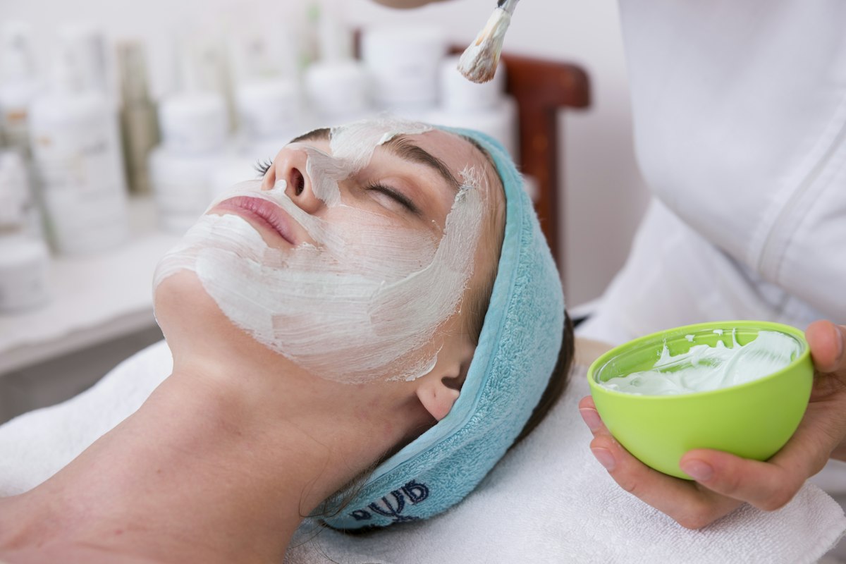 Esthetician applying a facial mask